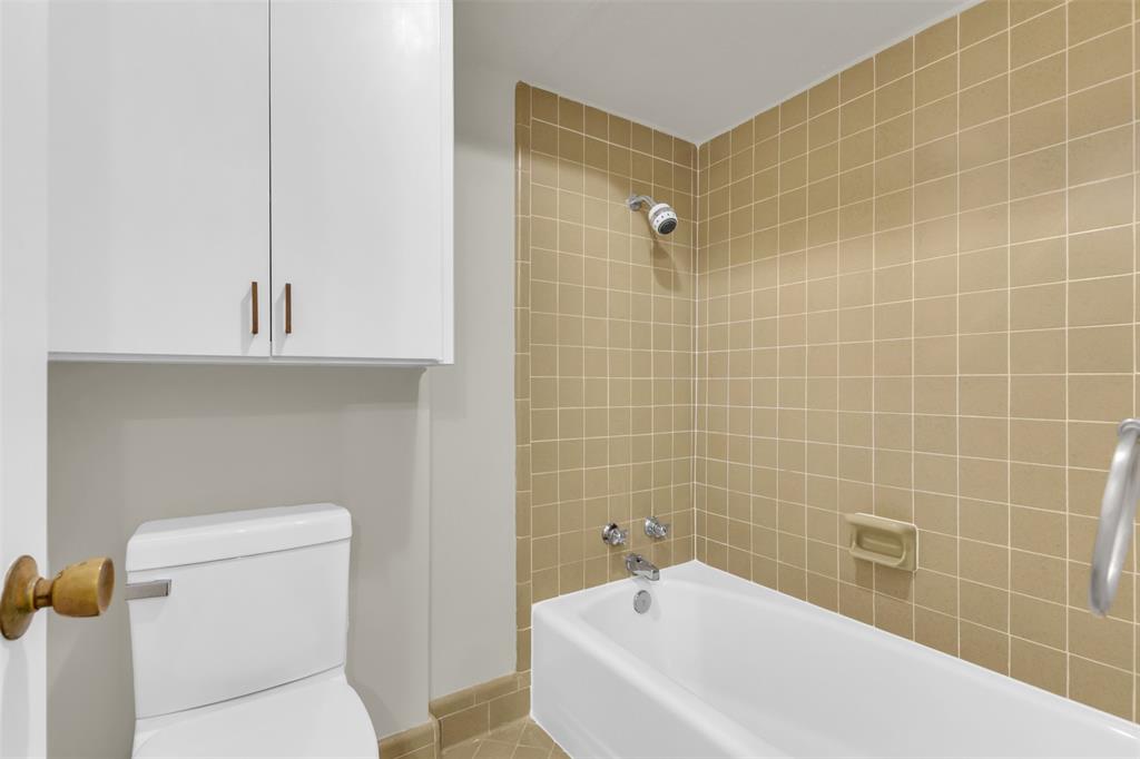 10763 Villager Road, Unit A Dallas, TX 75230 - Photo 17 of 21 a white bath tub sitting next to a white toilet