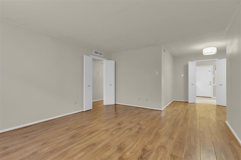 10763 Villager Road, Unit A Dallas, TX 75230 - Photo 6 of 21 a view of an empty room and wooden floor