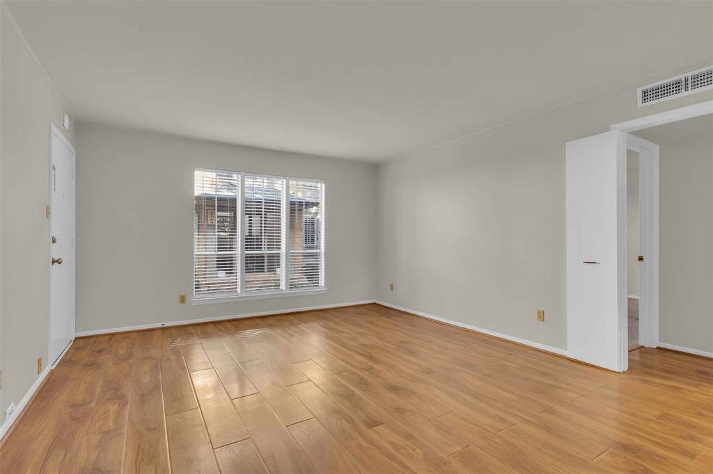 10763 Villager Road, Unit A Dallas, TX 75230 - Photo 7 of 21 a view of an empty room with wooden floor and a window