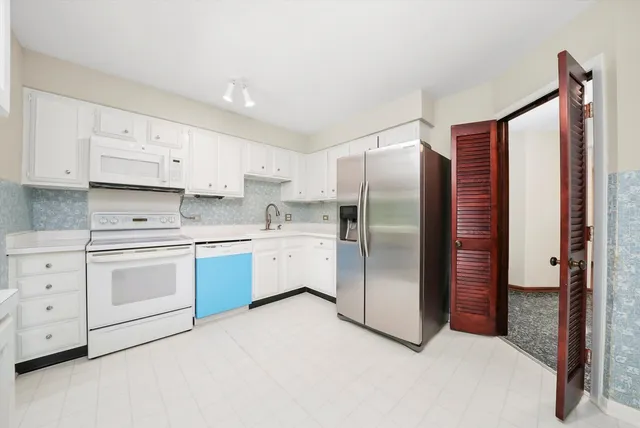 a kitchen with stainless steel appliances cabinets a sink and a refrigerator