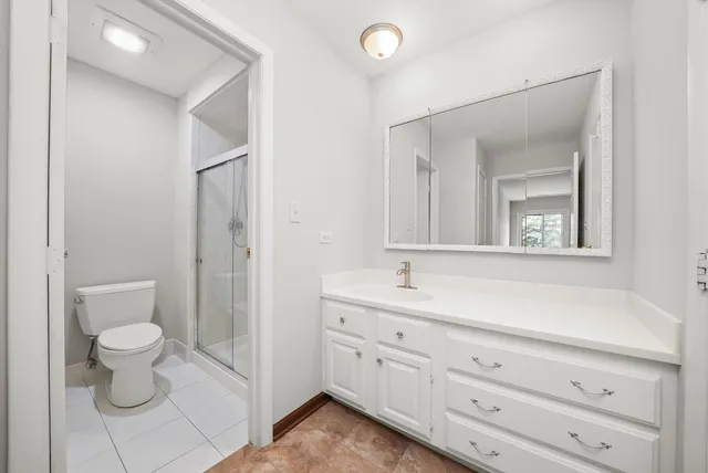 a bathroom with a toilet a sink and mirror