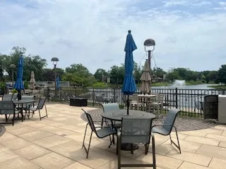 a view of pool with table and chairs under an umbrella