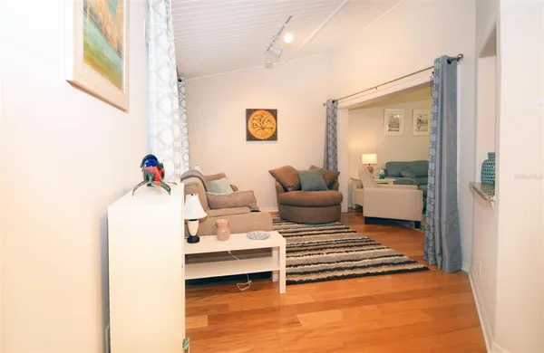 a living room with furniture and a potted plant next to a window