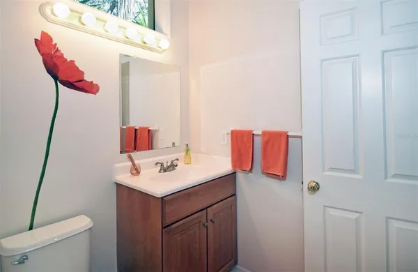a bathroom with a sink vanity mirror and toilet