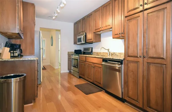 a kitchen with stainless steel appliances granite countertop a refrigerator a sink dishwasher and a stove