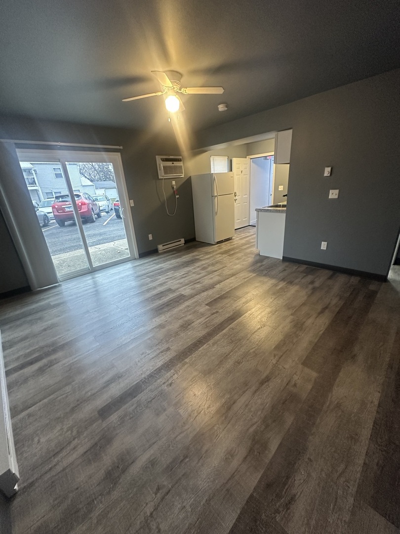530 East 3rd Street, Unit F Coal City, IL 60416 - Photo 4 of 5 an empty room with wooden floor and windows