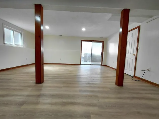 an empty room with wooden floor and entryway