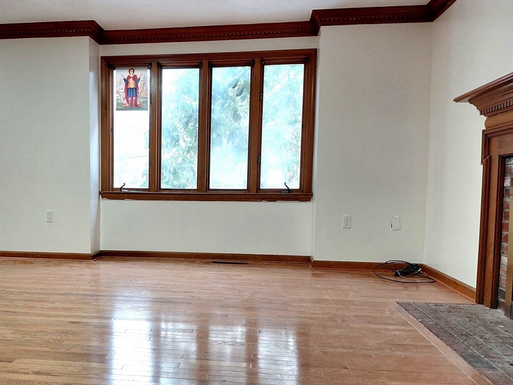 117 Metropolitan Avenue, Unit 117 Ashland, MA 01721 - Photo 2 of 15 a view of an empty room with wooden floor and a window