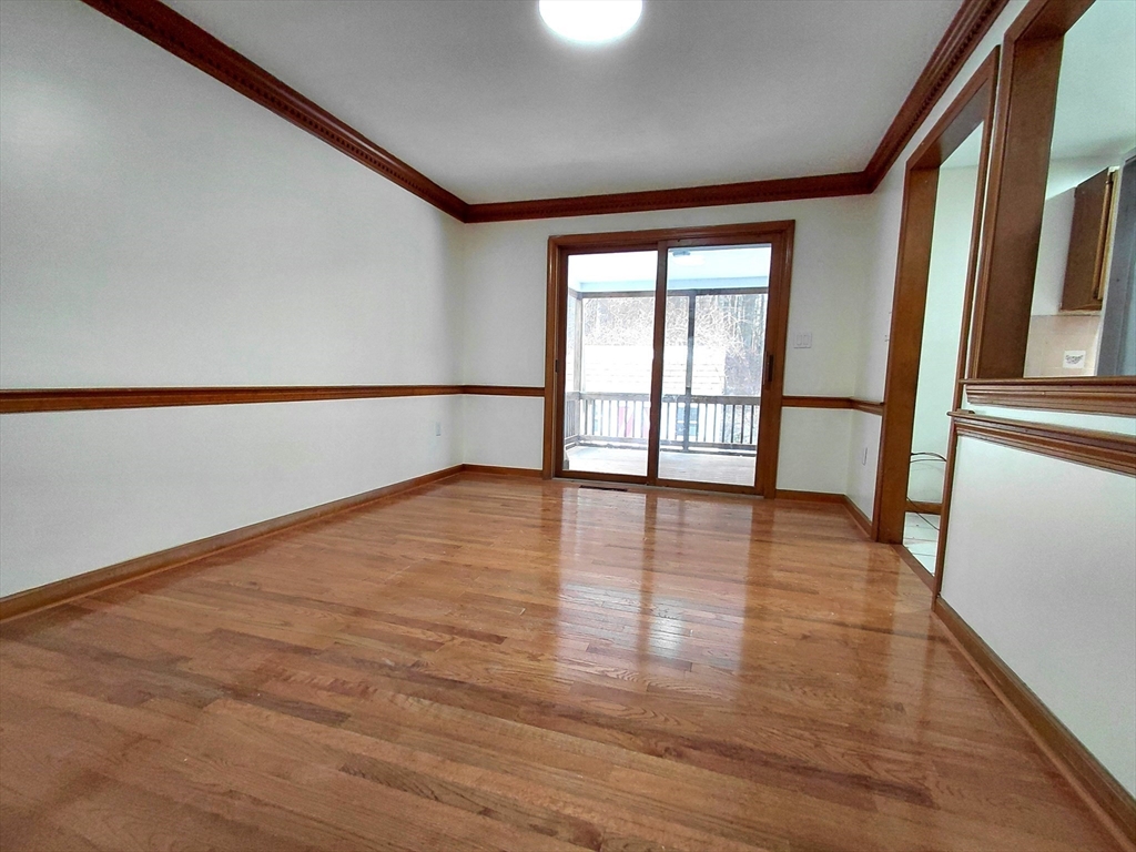117 Metropolitan Avenue, Unit 117 Ashland, MA 01721 - Photo 9 of 15 a view of an empty room with wooden floor and a window