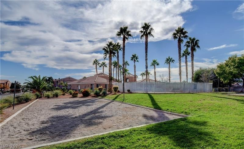 3318 North Decatur Boulevard, Unit 2093 Las Vegas, NV 89130 - Photo 10 of 10 Palm trees frame a community green space, featuring a sand court and verdant lawn.