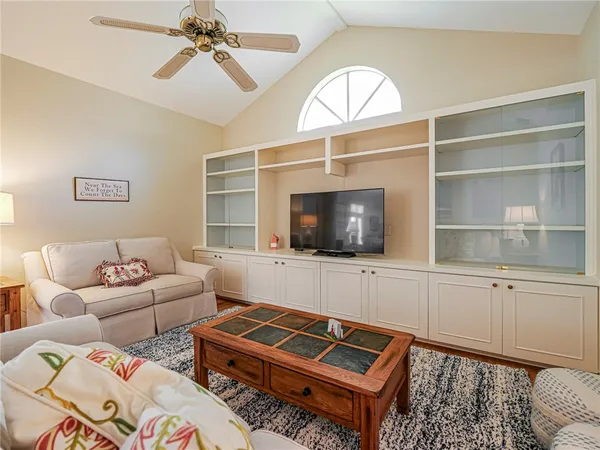 a living room with furniture a flat screen tv and a window