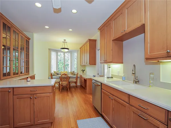 a kitchen with stainless steel appliances wooden floors and wooden cabinets