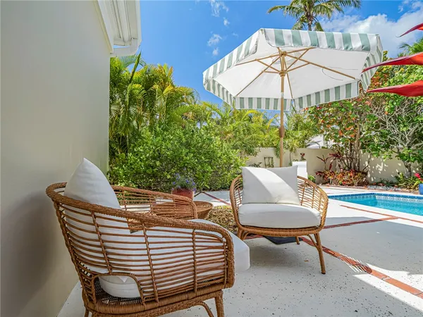 a view of a patio with a table and chairs under an umbrella
