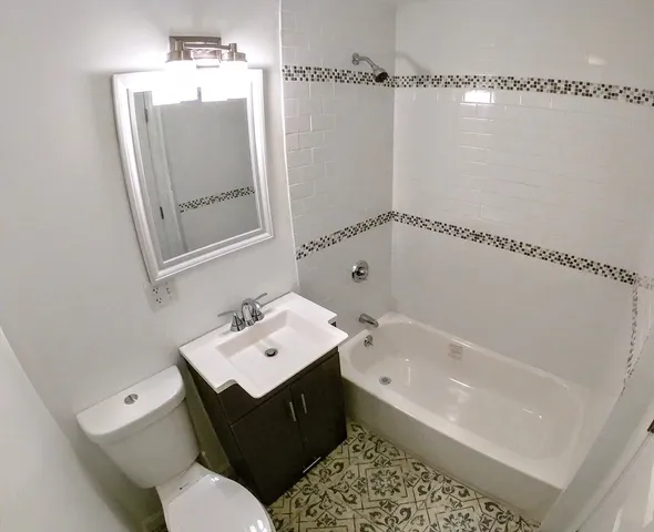 a bathroom with a bathtub sink vanity and toilet
