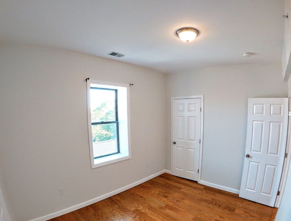 608 Shawmut Avenue, Unit 3 Boston, MA 02118 - Photo 19 of 22 an empty room with wooden floor and windows