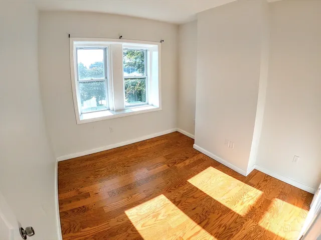 a view of a room with wooden floor and a window