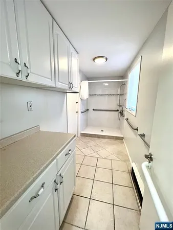 a view of a hallway with wooden floor and a chandelier