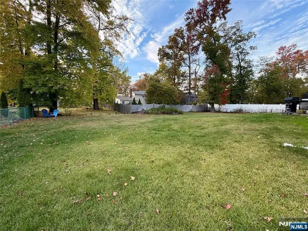 a view of a house with a big yard and large trees