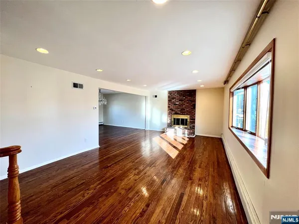 a view of a living room with wooden floor and stairs