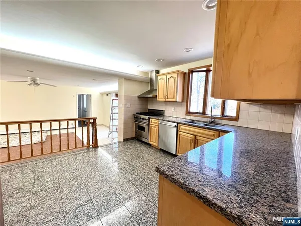 a kitchen with stainless steel appliances granite countertop a sink stove and cabinets