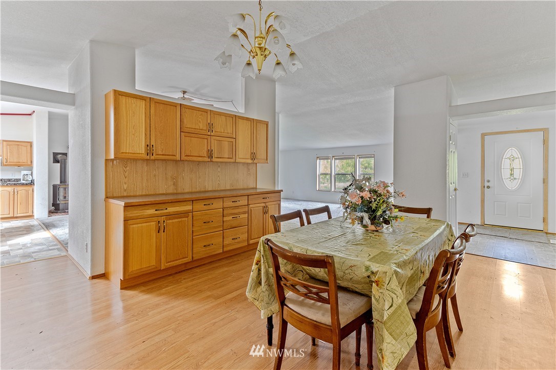440 Kirkland Road Chehalis, WA 98532 - Photo 5 of 36 a dining room with wooden floor a chandelier a wooden table and chairs