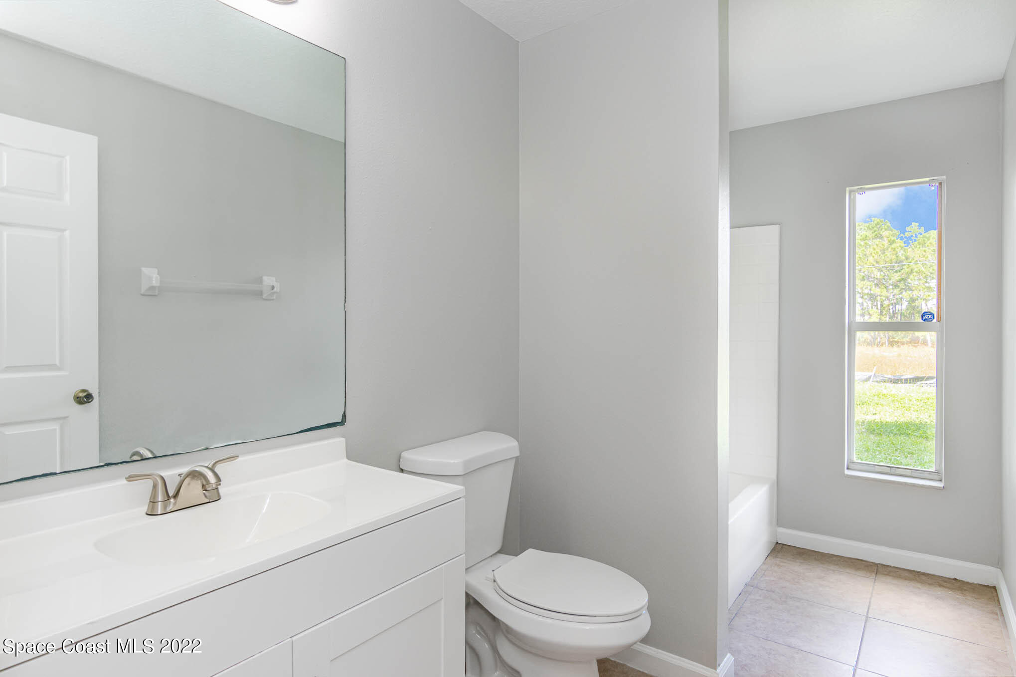 909 San Rafael Road Southwest Palm Bay, FL 32908 - Photo 19 of 24 a bathroom with a sink toilet and window
