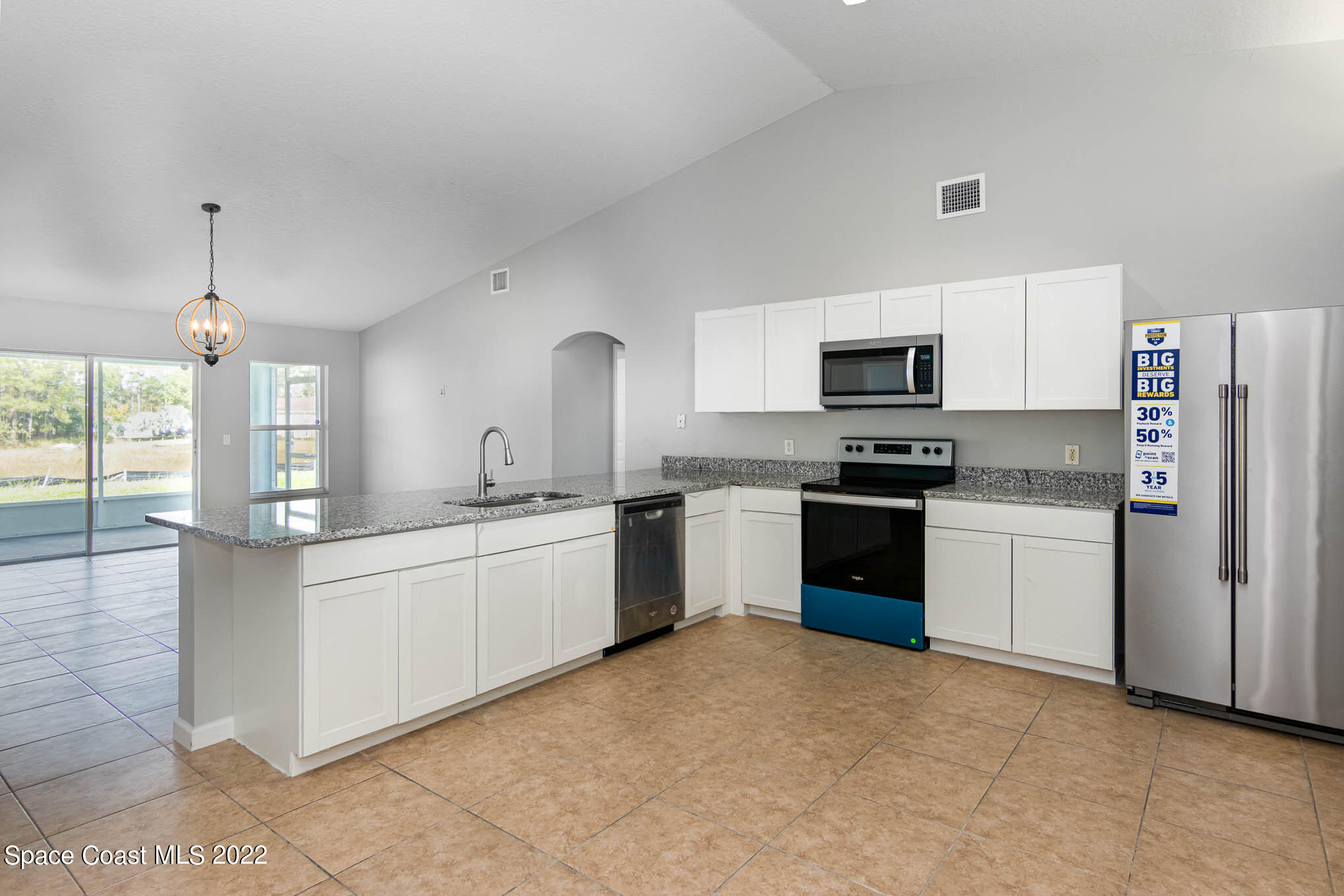 909 San Rafael Road Southwest Palm Bay, FL 32908 - Photo 8 of 24 a kitchen with granite countertop white cabinets and stainless steel appliances
