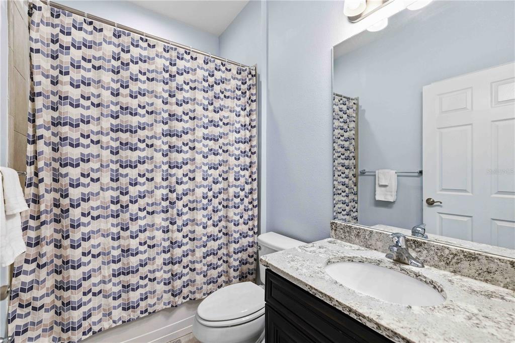 10920 79th Street East Parrish, FL 34219 - Photo 28 of 73 a bathroom with a granite countertop sink a toilet and a mirror