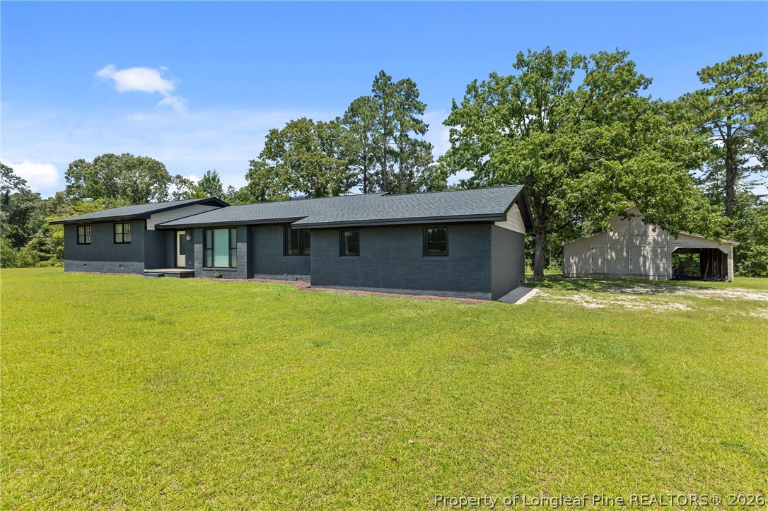 1250 Overhills Road Linden, NC 28356 - Photo 2 of 34 a front view of house with yard and trees in the background