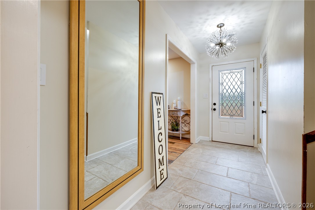 1250 Overhills Road Linden, NC 28356 - Photo 3 of 34 a view of a hallway with a chandelier and glass door