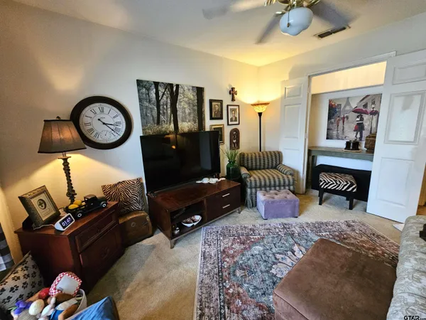 a living room with furniture a rug and white walls