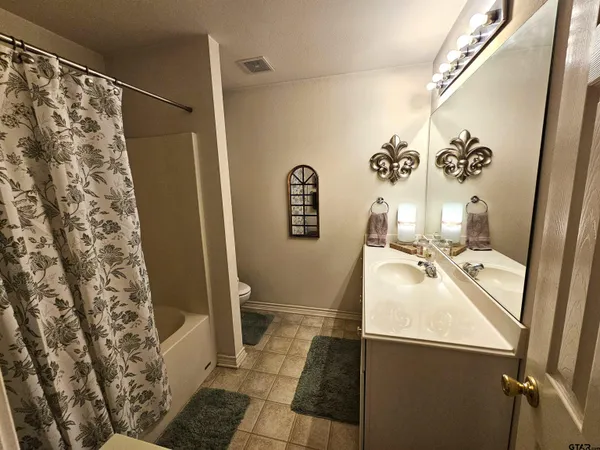 a bathroom with a sink and mirror with toilet