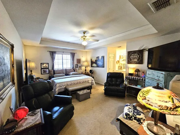 a living room with furniture a flat screen tv and kitchen view