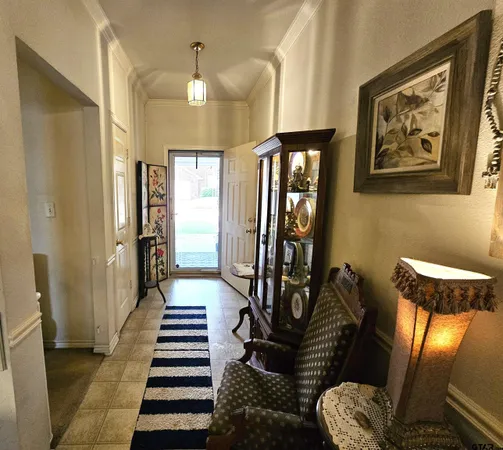 a view of a hallway with furniture and paintings on the wall