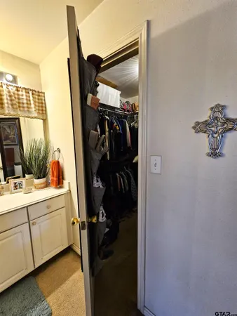 a view of walk in closet with clothes and shoes
