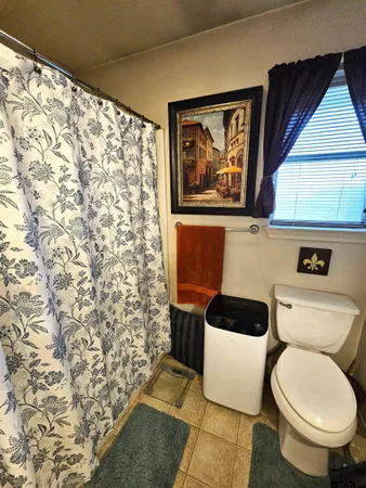 a bedroom with a bed a couch and a flat screen tv