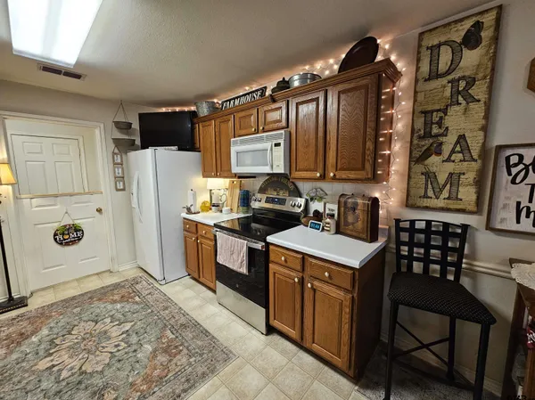 a kitchen with granite countertop a refrigerator stove and sink