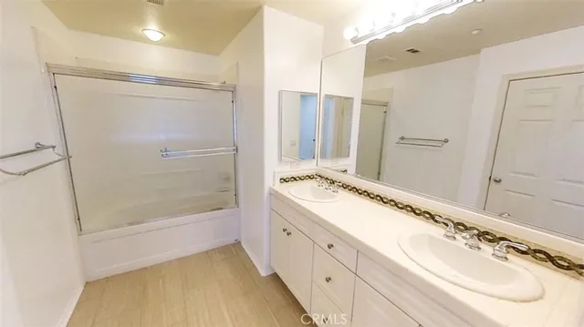 a bathroom with a double vanity sink mirror double and shower