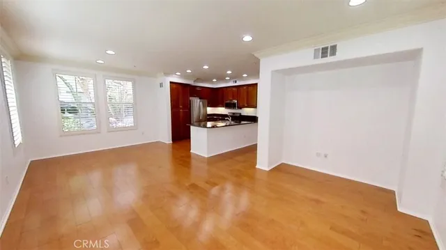 a view of an empty room with a kitchen