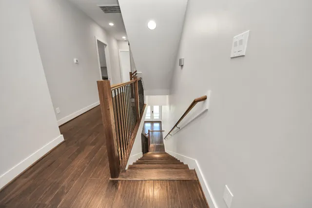 a view of empty room with wooden floor and windows