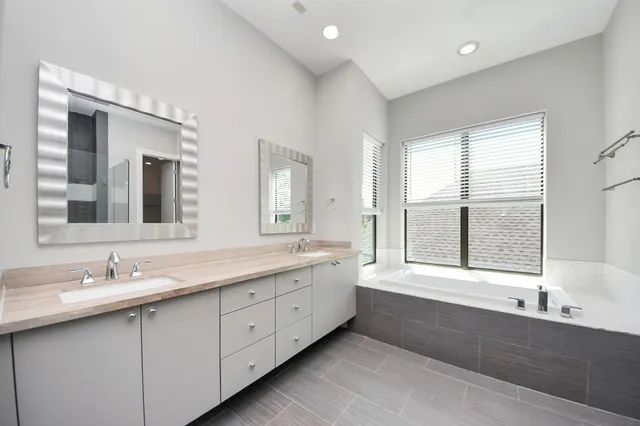 a spacious bathroom with a large tub shower and sink