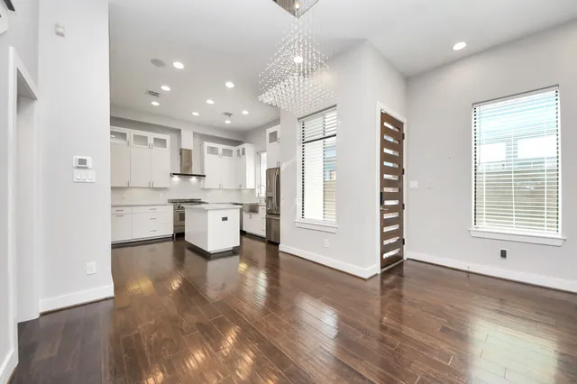 a kitchen with stainless steel appliances granite countertop a stove a sink a refrigerator and chairs