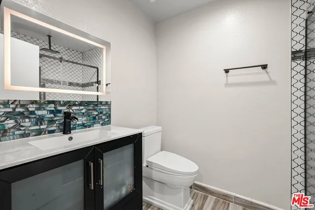 a bathroom with a sink a toilet and mirror