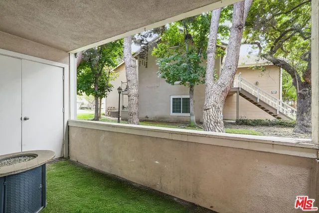 a view of a house with a balcony and a tree