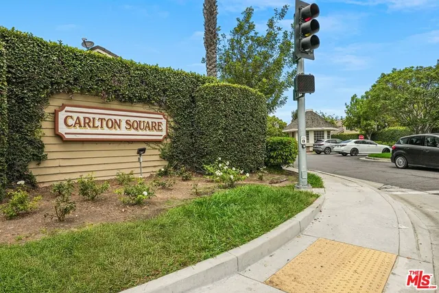 a view of a street with potted plants and a building