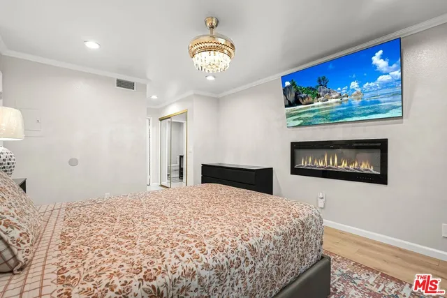 a bedroom with a large bed and a chandelier