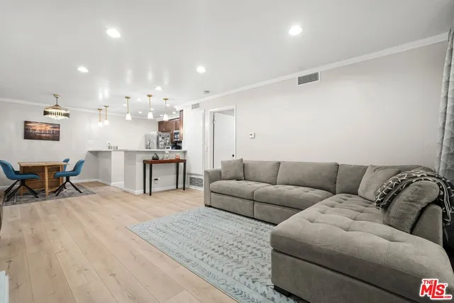 a living room with furniture and kitchen view