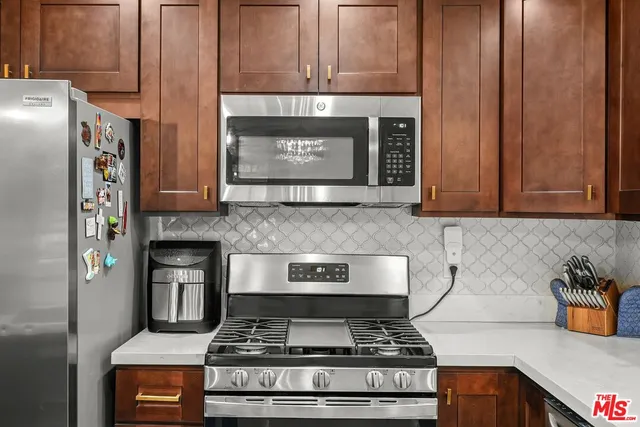 a kitchen with stainless steel appliances granite countertop a stove and a refrigerator