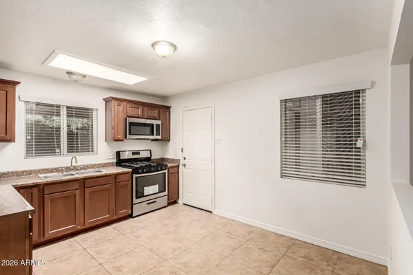 a kitchen with stainless steel appliances granite countertop a stove a sink and a microwave