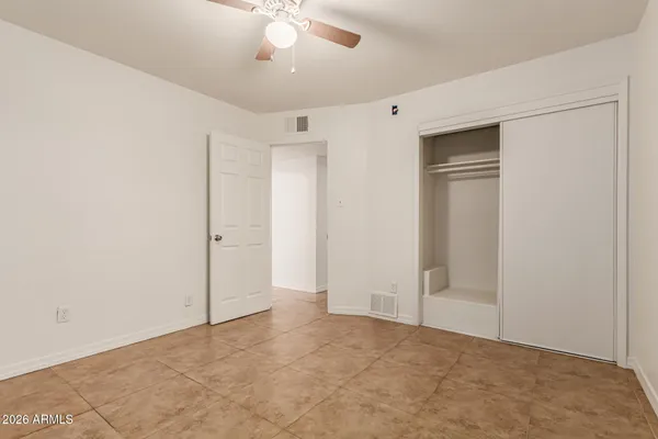 a view of an empty room with a chandelier fan